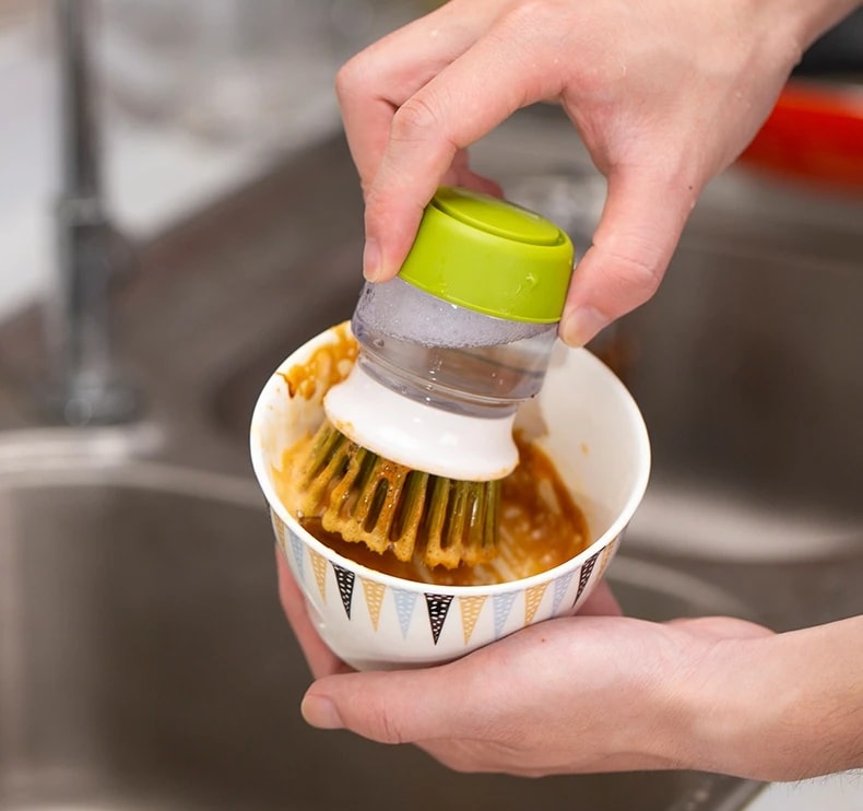 Scrubbing a bowl with the Jalenza soap dispensing brush