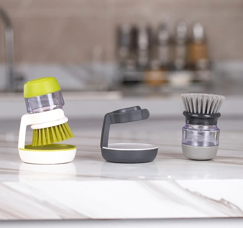 Green and gray Jalenza dish brushes with the storage stand on a marble counter